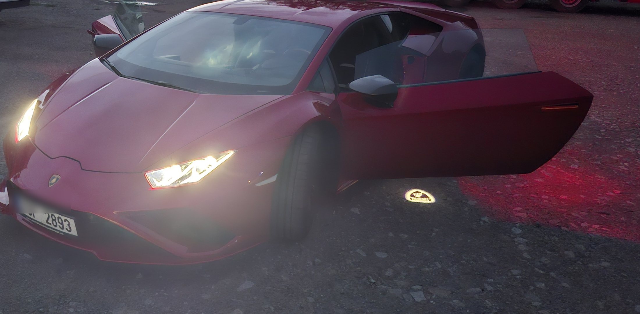 Lamborghini Huracán EVO v barvě Rosso s otevřenými dveřmi za soumraku